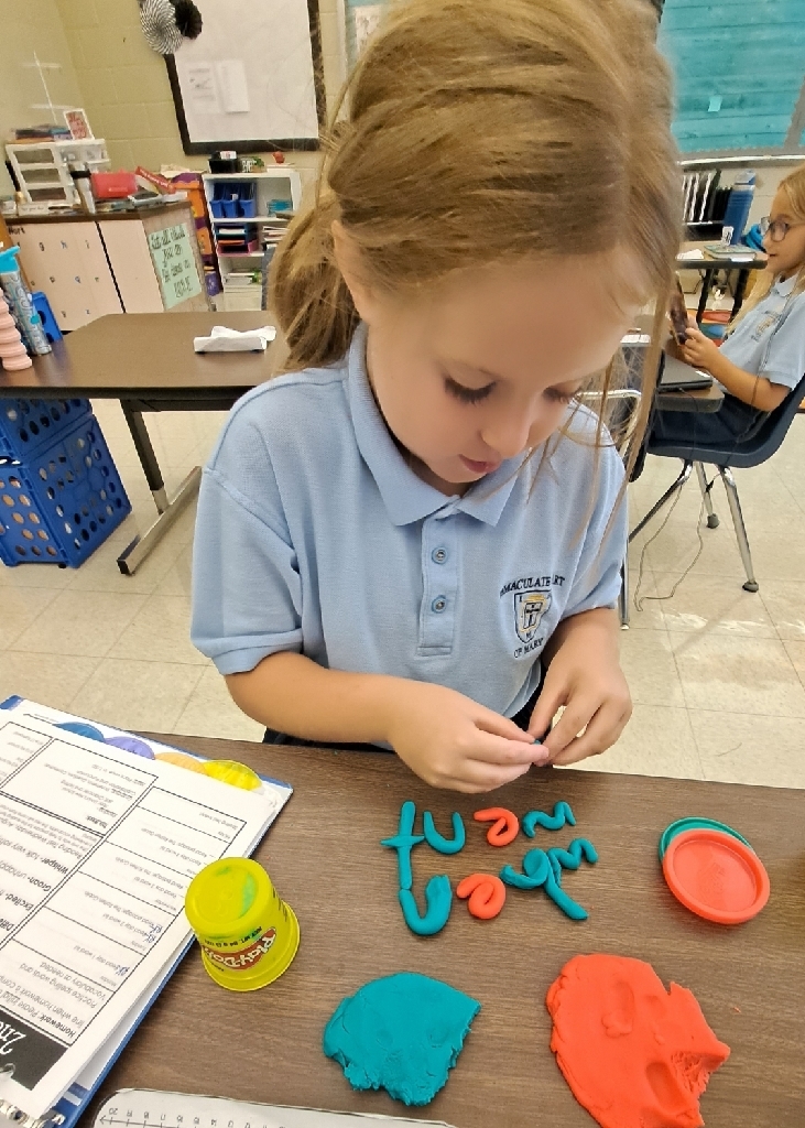 student building spelling words with playdoh 