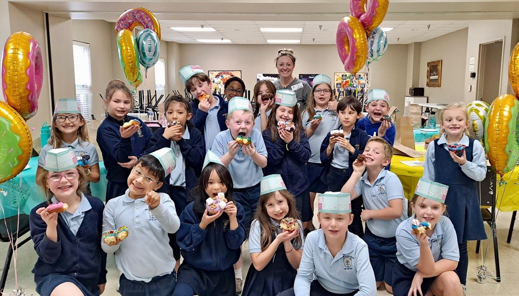 2nd graders decorating donuts